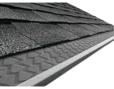 Gutter cover installed beneath roof shingles